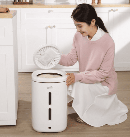 쌀통을 보고 흐믓해 하는 여자 모습 